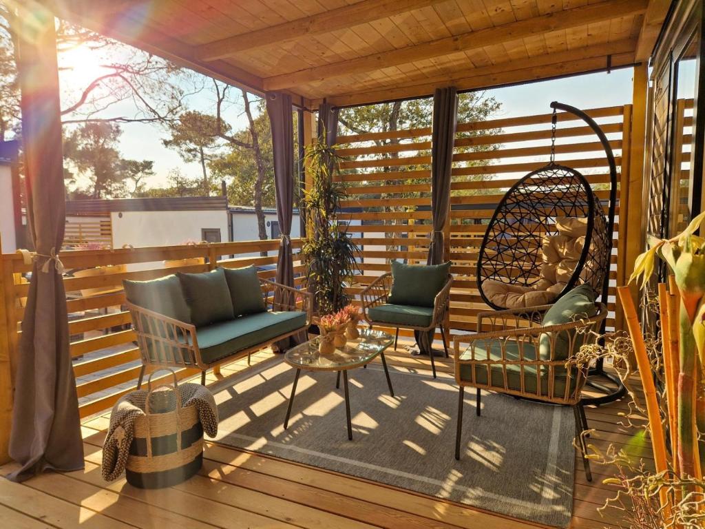 a porch with two chairs and a table on a deck at Mobile Homes MaLu in Biograd na Moru