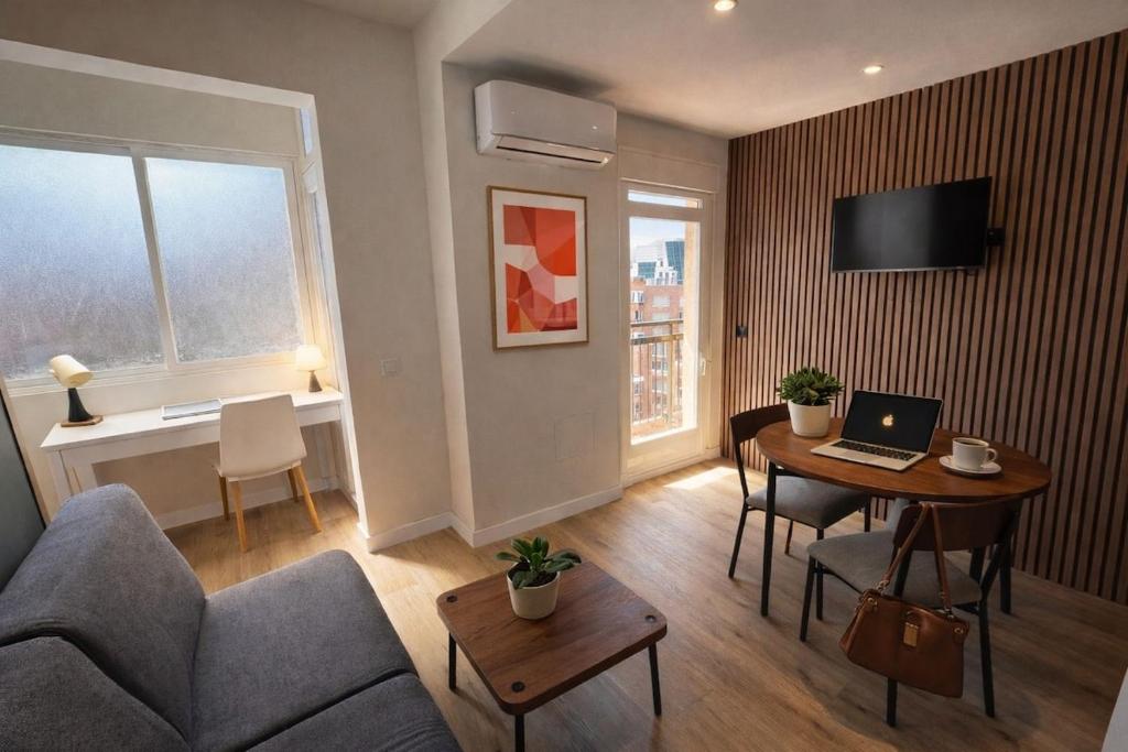 a living room with a couch and a table with a laptop at Winahost Madrid Towers II in Madrid