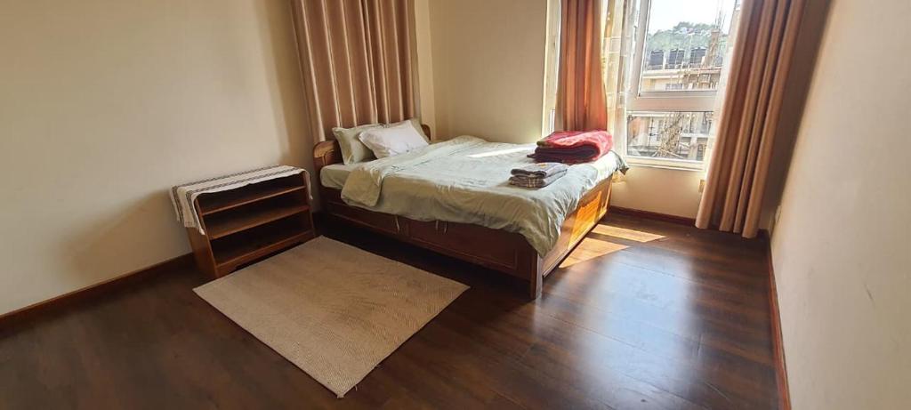 a small bedroom with a bed and a window at The LYNMAR HOMESTAY at Mawkynroh in Shillong