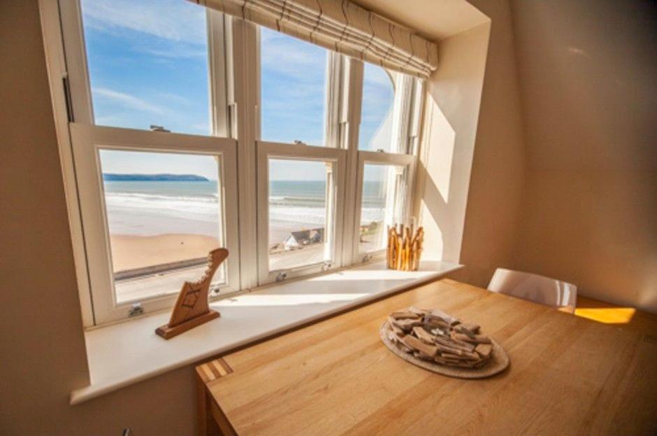 a room with a window with a view of the beach at Hartland Heights in Woolacombe