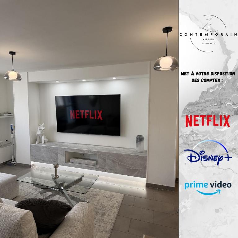 a living room with a tv on a wall at Le Contemporain in Troyes