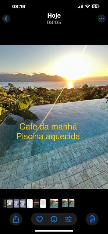 a screen of a cell phone with a picture of a pool at Maluhia Ilhabela 1 in Ilhabela