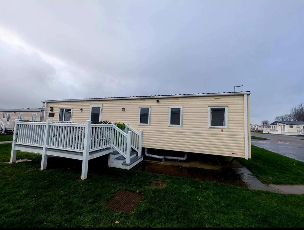 a mobile home with a porch and a deck at Ty Mawr Summerbreeze in Kinmel Bay