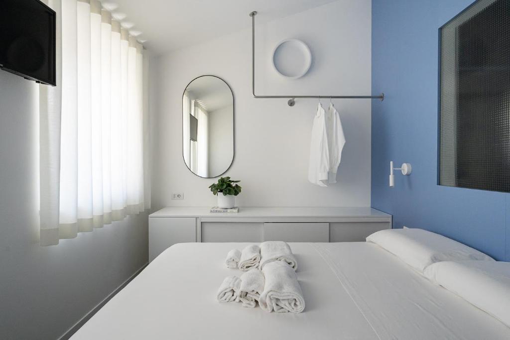 a white room with a bed with towels on it at VIVO Rooms in Civitanova Marche