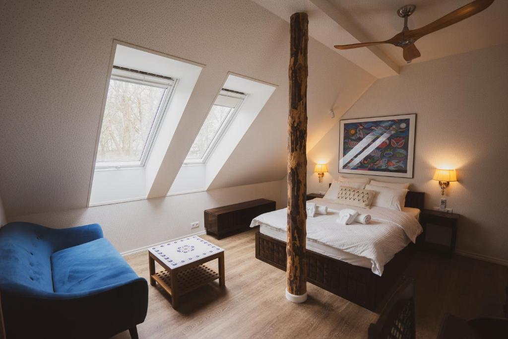 a bedroom with a bed and a blue chair at Mia Hotel in Orissaare