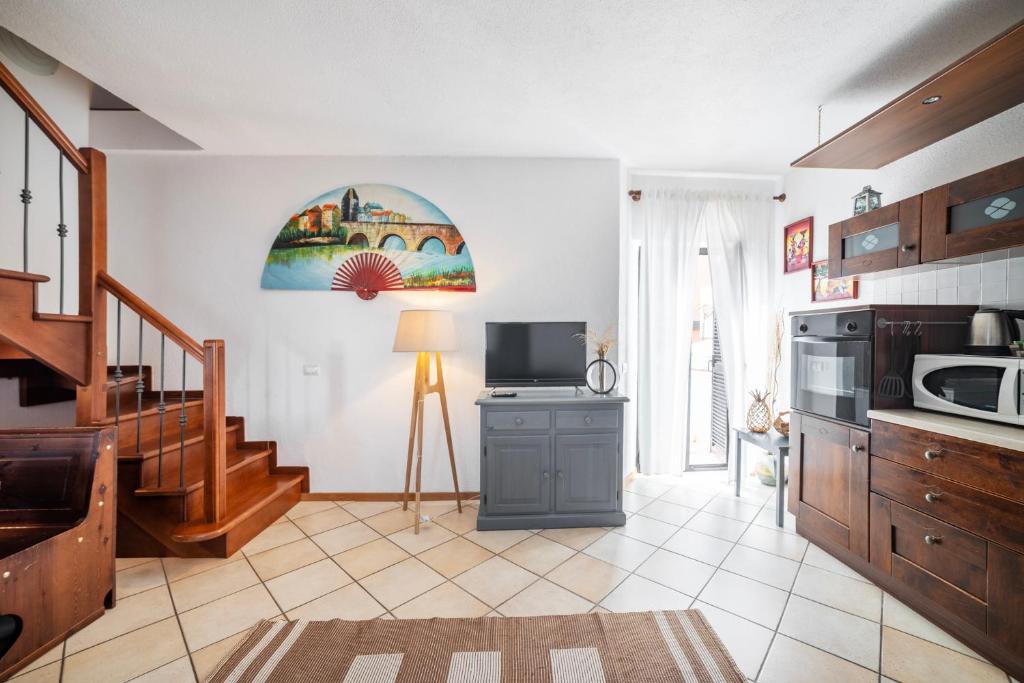 a living room with a kitchen with a microwave at Camping Italia 90 Two Levels Apartment in Domaso
