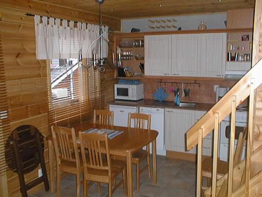 a kitchen with a table and chairs and a microwave at Rinnetahko in Tahkovuori