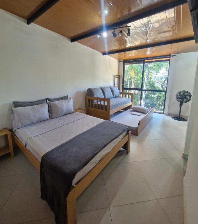 a bedroom with a large bed and a couch at Loft da Árvore in Petrópolis