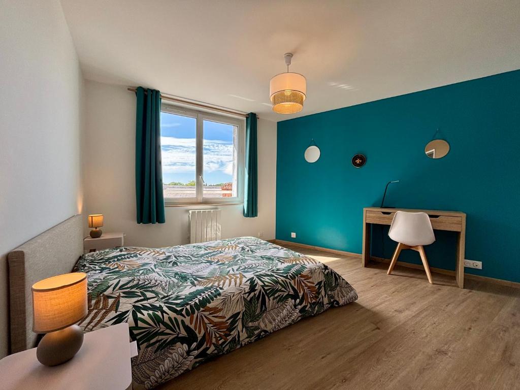 a bedroom with a bed and a desk and a window at La Boierie - City Appart's in La Flèche