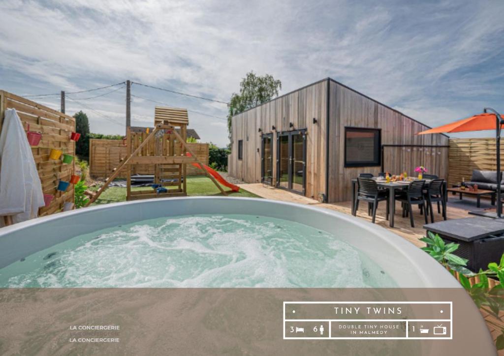 a hot tub in the backyard of a house at Tiny Twins - TinyHouse 6 personnes à Malmedy by LaConciergerie in Malmedy