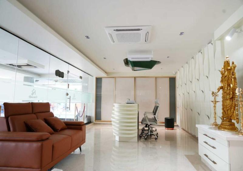 a living room with a brown couch and a desk at K R GRAND in Vijayawāda