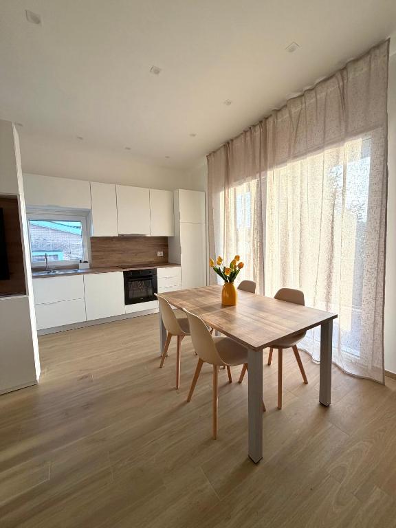 a kitchen and dining room with a table and chairs at Velù Apartment in Porto Viro