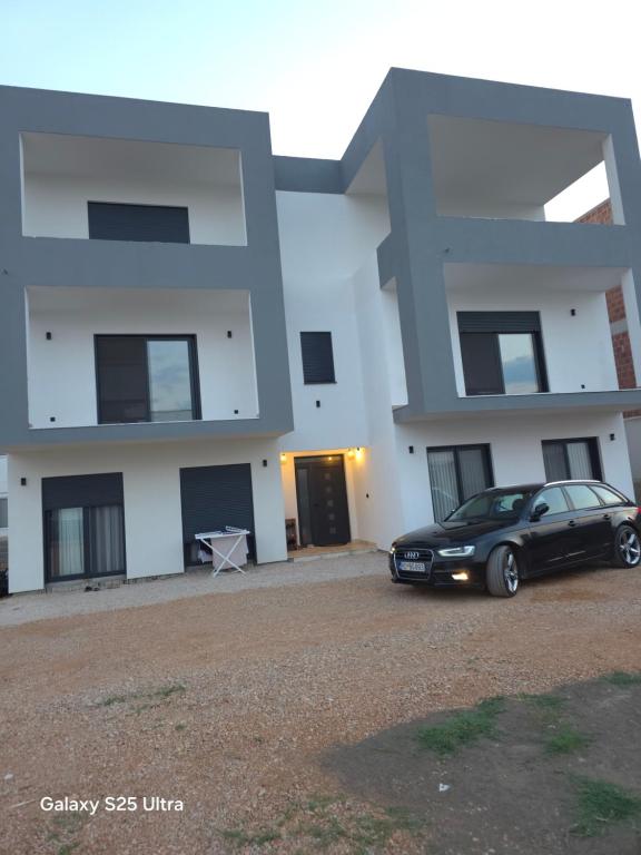 a black car parked in front of a house at Apartmani Edi Premium in Ulcinj