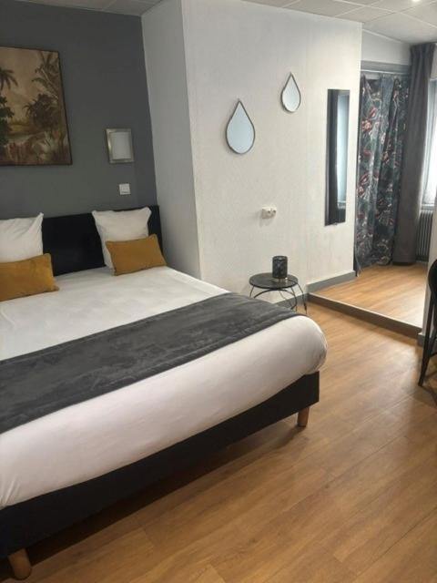 a bedroom with a large bed in a room at Hotel de Normandie in Lyon