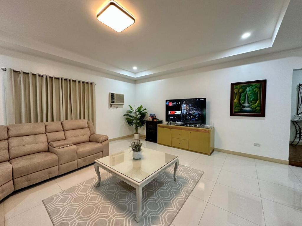 a living room with a couch and a tv at The Penthouse at Sapphire in San Agustin