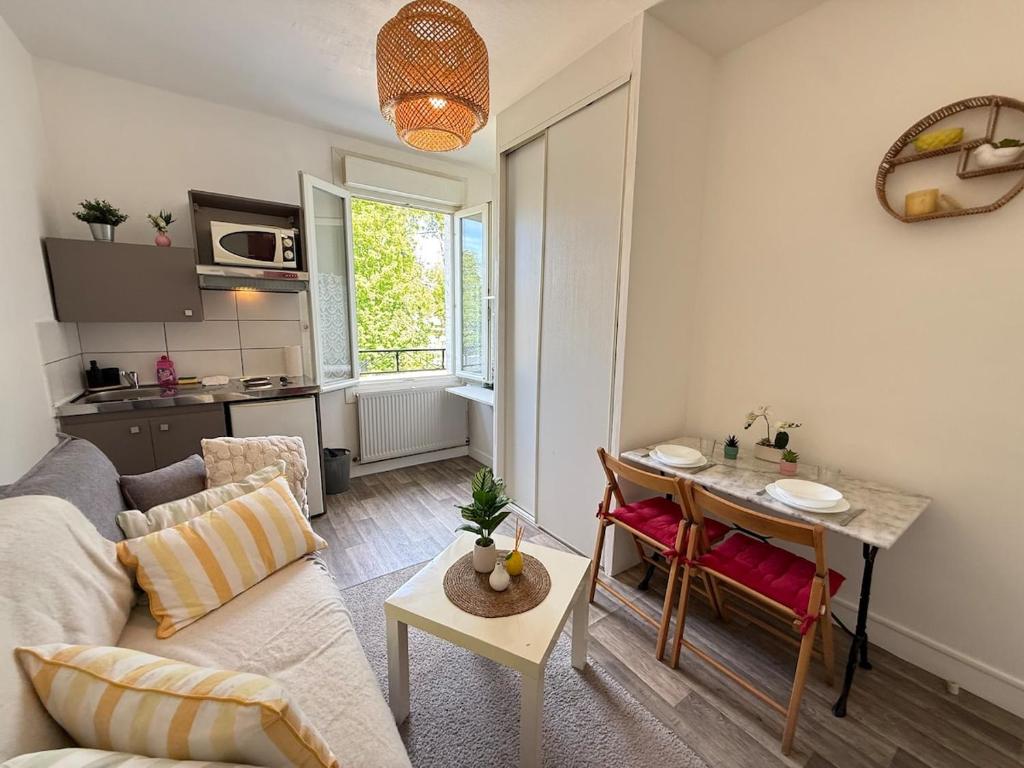 a living room with a couch and a table at Studio cosy parking in Margny-lès-Compiègne