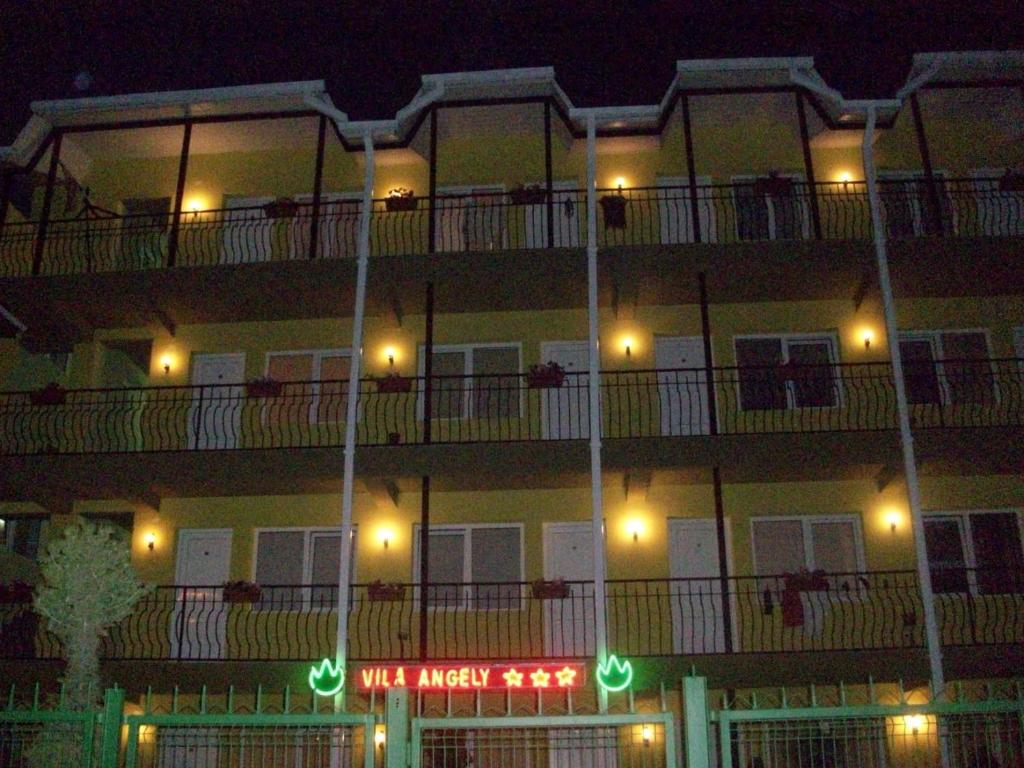 a building with a sign on the side of it at night at Angely Summer Vila in Eforie Nord