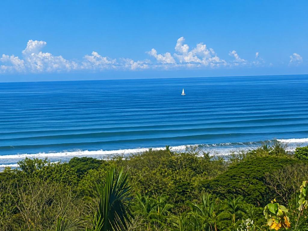 a sail boat in the ocean on the beach at Vista Naranja Retreat in Santa Teresa Beach