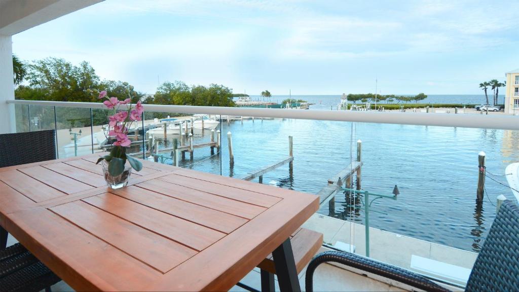 a wooden table with a vase of flowers on a balcony at 124 Mariners Club in Key Largo