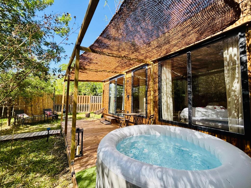 a hot tub on the deck of a house at Bambou Lodge & Spa in Arles