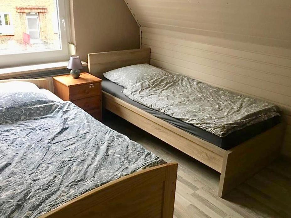 two twin beds in a bedroom with a window at Handwerkerunterkunft in Elmshorn