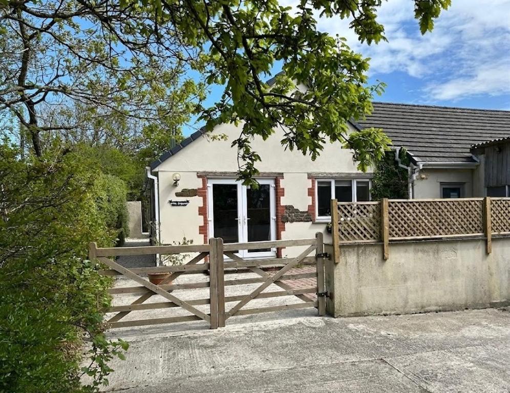 a house with a wooden fence in front of it at The Shippon in Holsworthy