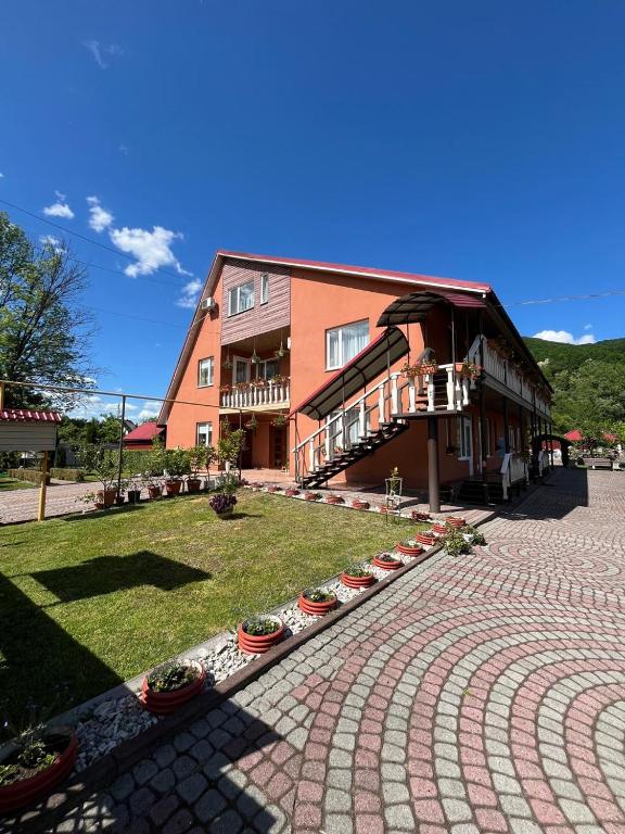 a large building with a brick courtyard in front of it at Vivat in Solochyn