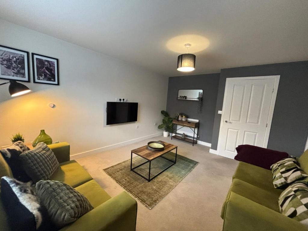 a living room with a couch and a tv at 3 Beds with off-street parking for 2 cars, fast Wifi, sleeps 6 in Ashby de la Zouch