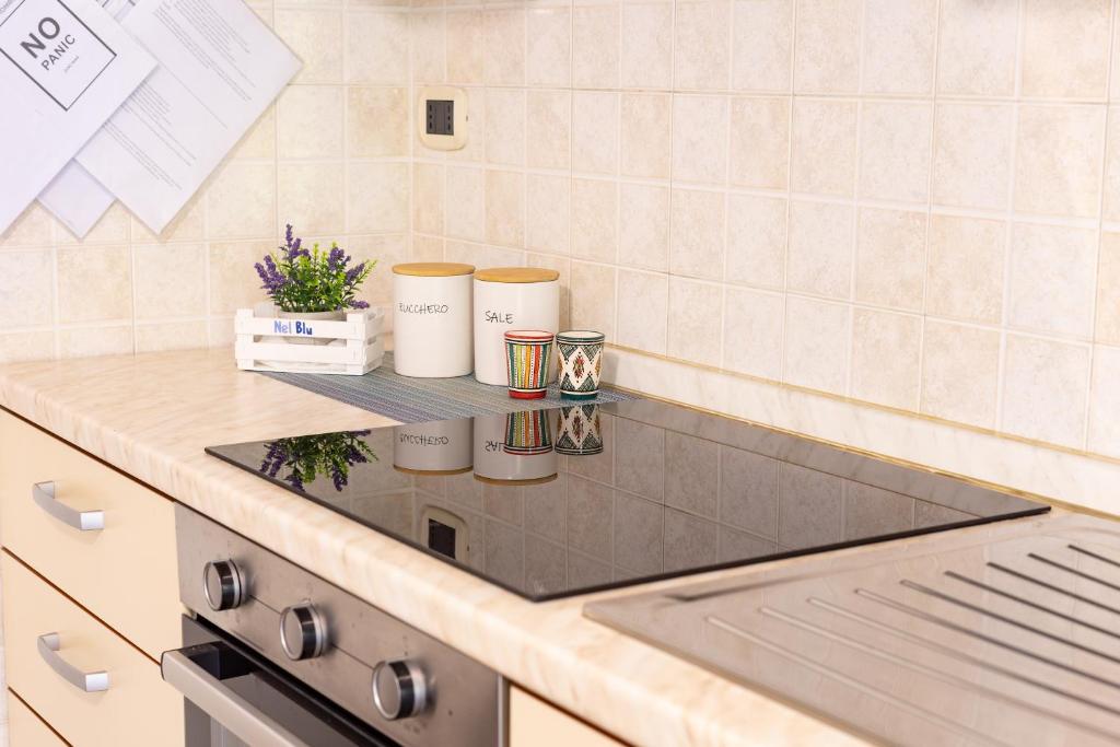 a kitchen counter with three cups on a shelf at Casa Nel Blu in SantʼAlessio Siculo