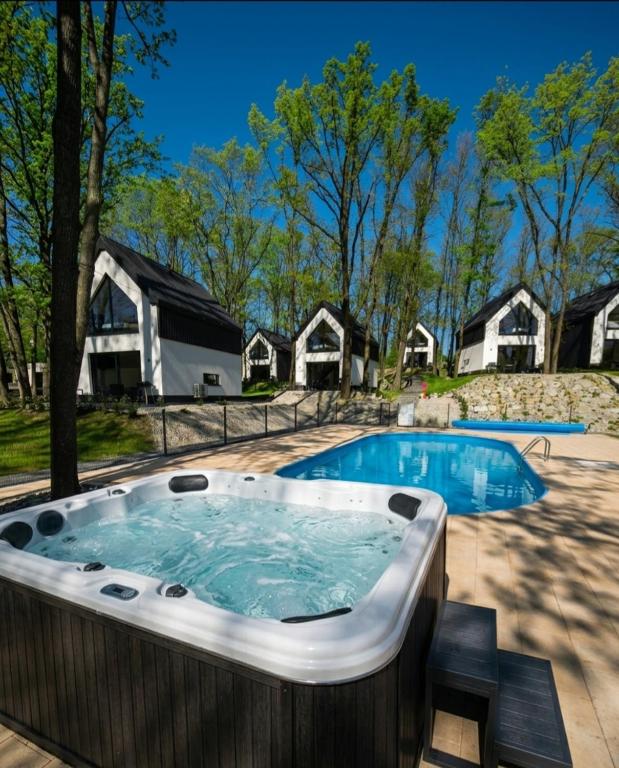 a large hot tub in a yard with houses at Treehouses in Skorochow