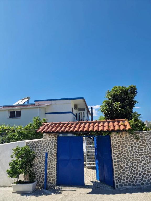 a house with a blue door and a wall at Guest House KrisHen in Përmet