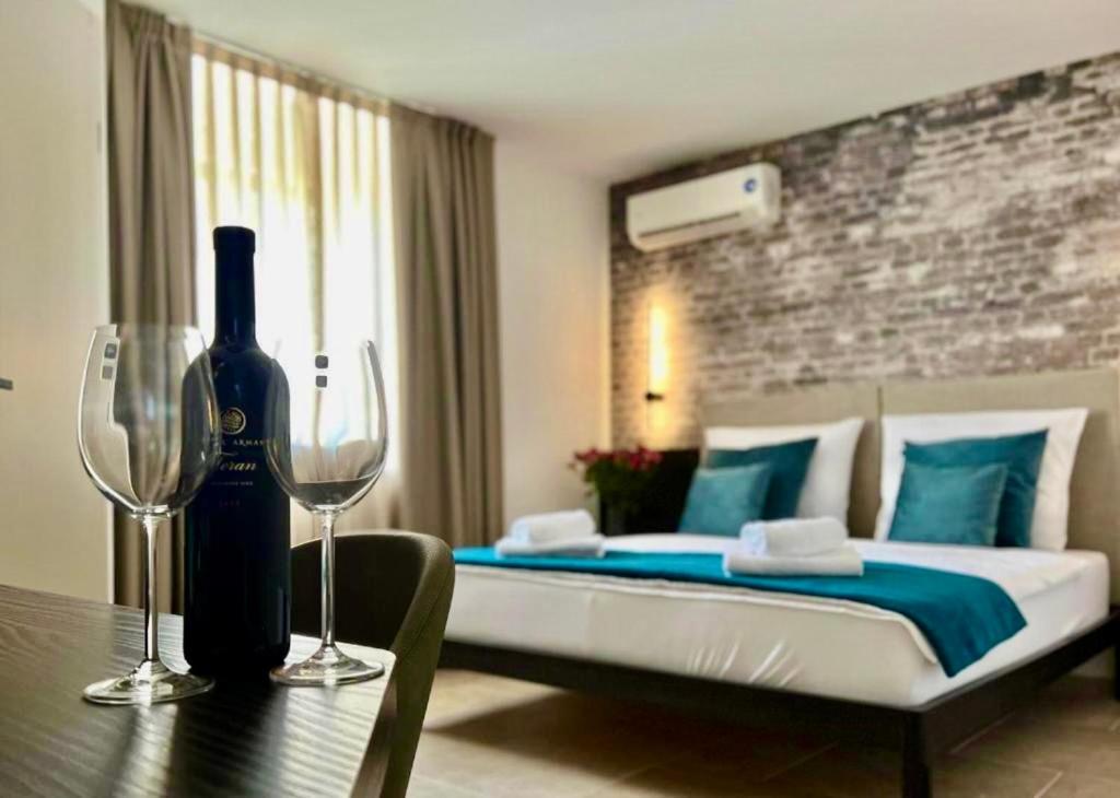 Un dormitorio con una cama con una botella de vino. en Arena Prestige Rooms, en Pula