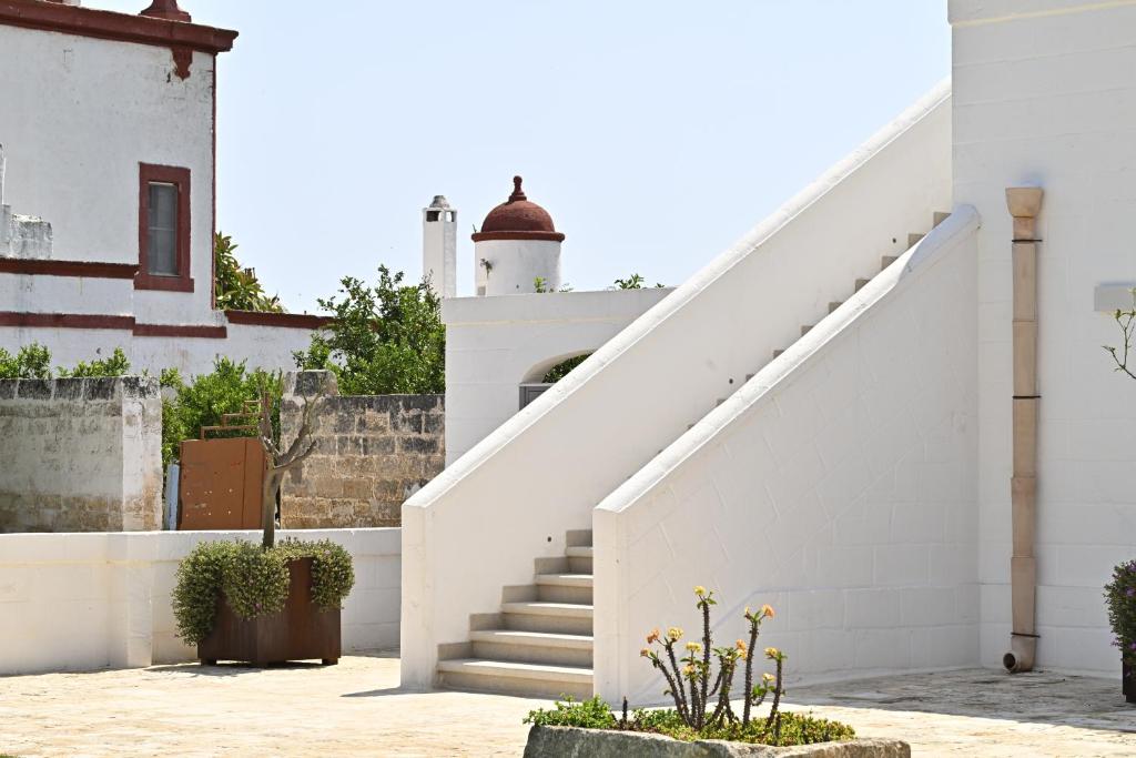 a staircase leading to a white building with a stair case at Corte di Torre Spaccata in Torre Canne