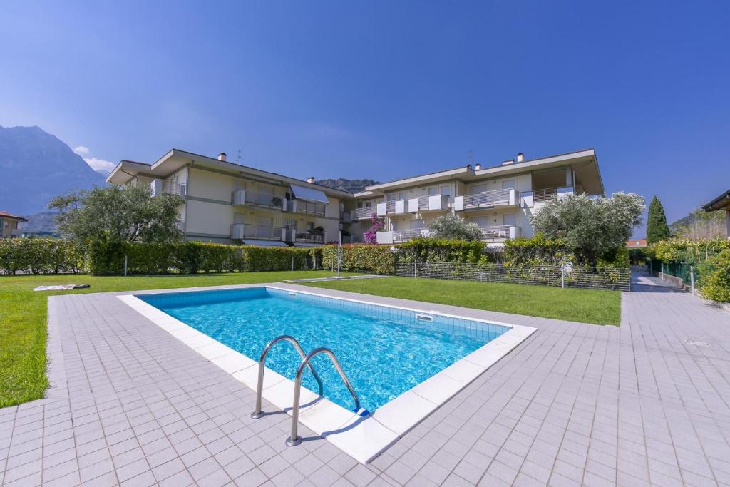 a swimming pool in front of a building at Torbole Relax, Pool & Balcony Apartment in Nago-Torbole