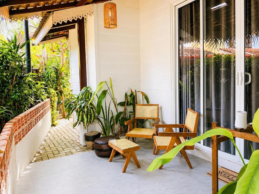 a patio with chairs and plants on a house at The Bay House in Weligama