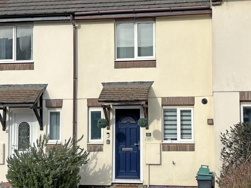 a house with a blue door and windows at Twenty One in Westward Ho