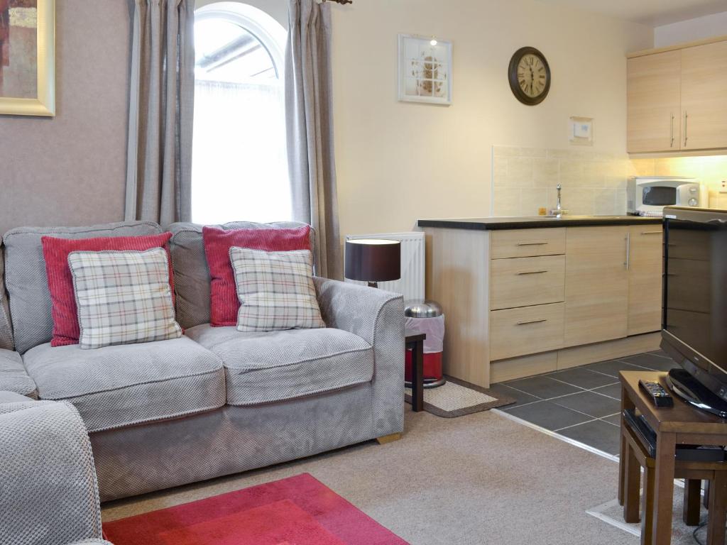 a living room with a couch and a kitchen at Eldin Hall Cottage 2 - Uk2484 in Scarborough