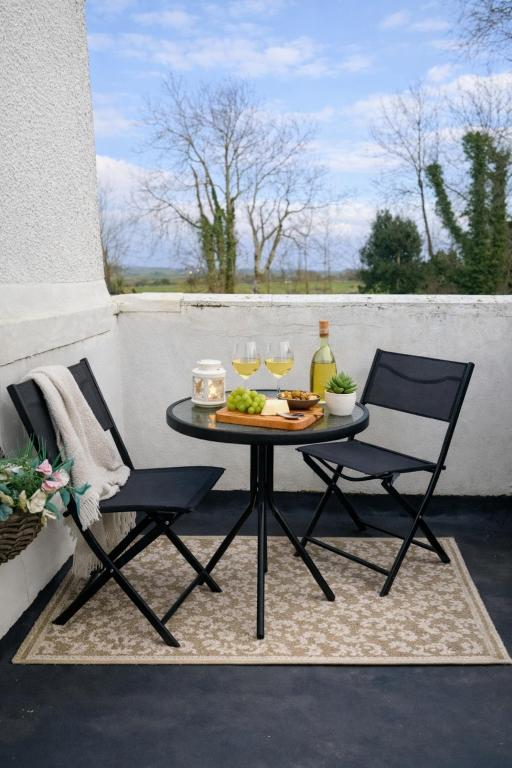 a table with two chairs and wine glasses on a patio at The Dearham Lonnin Nook in Dearham