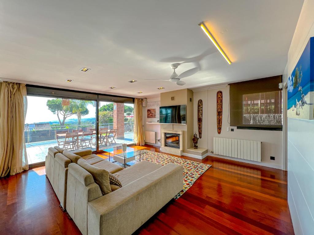 a living room with a couch and a fireplace at Vivalidays Villa Amatista in Caldes d'Estrac