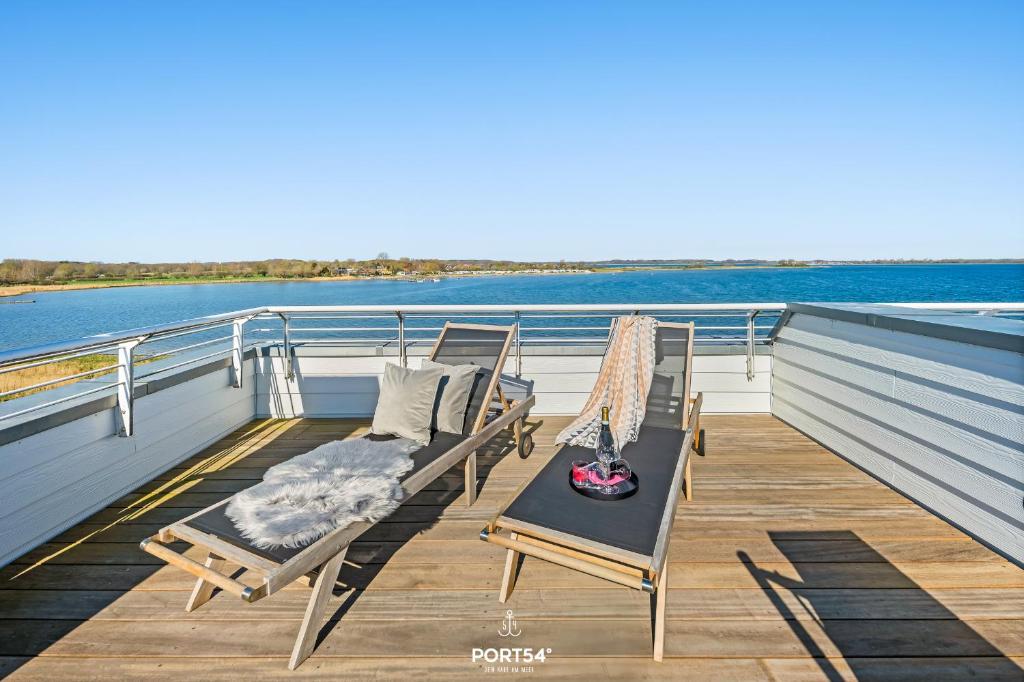 a couple of chairs sitting on the deck of a boat at Ferienhaus Hamptons Beach House Olpenitz in Olpenitz