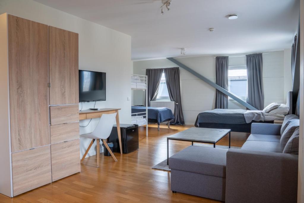 a living room with a couch and a bed and a tv at Hotell TunaPark in Eskilstuna