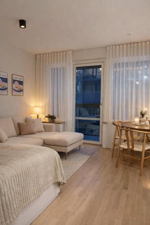 a living room with a bed and a table at Modern studio with balcony in Stockholm