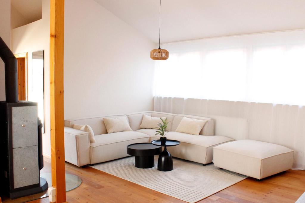 a living room with a white couch and a table at Das Nomadenhaus - Garten, Grill, Nähe Köln in Bergheim