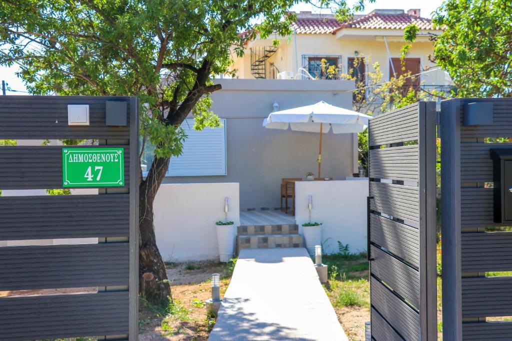 a house with a gate with a street sign and an umbrella at Christiana's House in Artemida