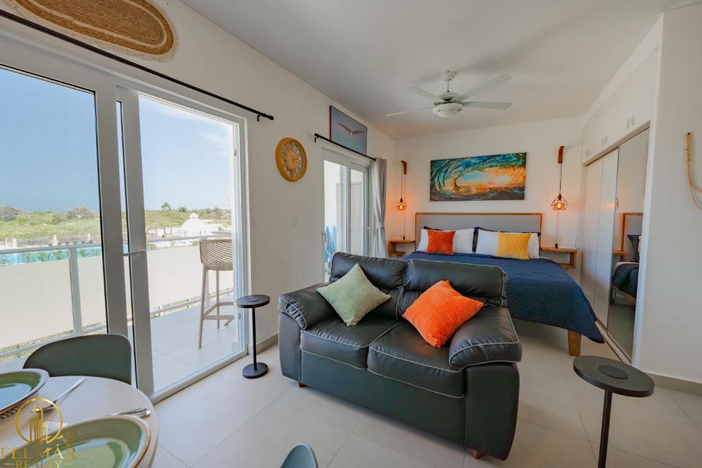 a bedroom with a couch and a bed and a balcony at Ideal accommodation for couples Sosúa, Santa Fe in Sosúa