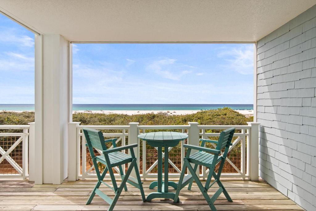 a table and chairs on a balcony with a view of the ocean at A112 Stella Aurea on 30A in Santa Rosa Beach