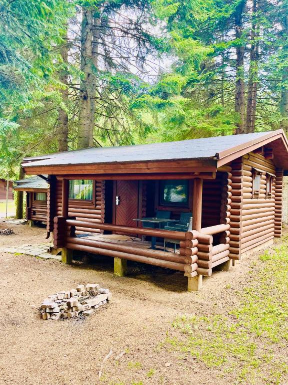 a log cabin in the woods with a porch at Villas Jagoda & Malina in Borovets