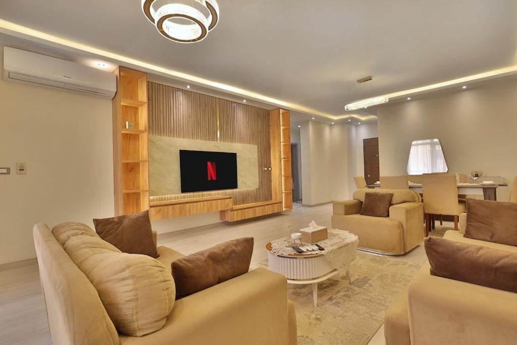 a living room with a couch and chairs and a table at A very, very special residential unit in Madinaty