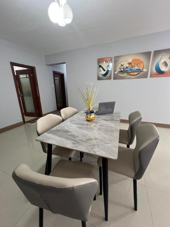 a dining room with a table and chairs with a laptop at Magnólia Home in Muceque Baia