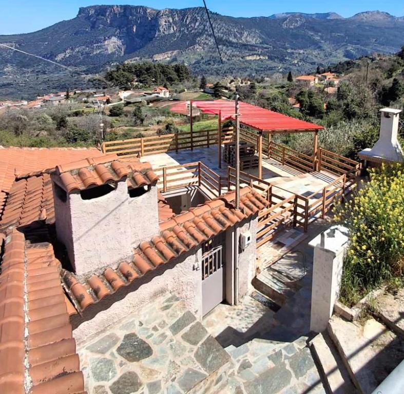 a building with a red roof with mountains in the background at Georgoulis Home in Ambelókipoi